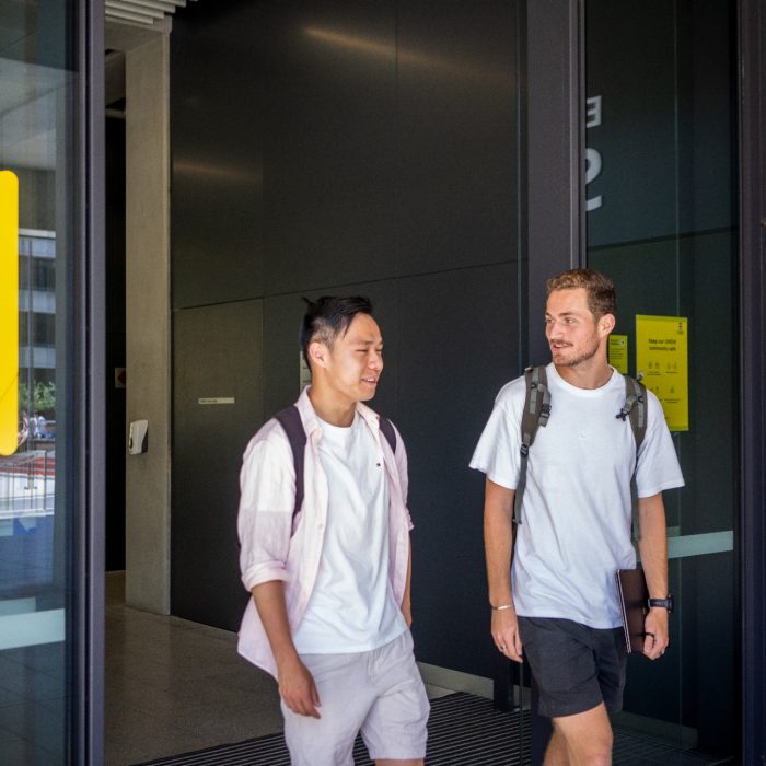 Two students chatting while exiting the Science & Engineering building on UNSW Kensington Campus