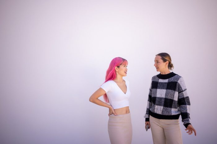 Students standing against a blank white wall on Paddington Campus