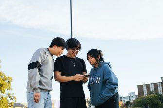 Students looking at one of their phones on campus