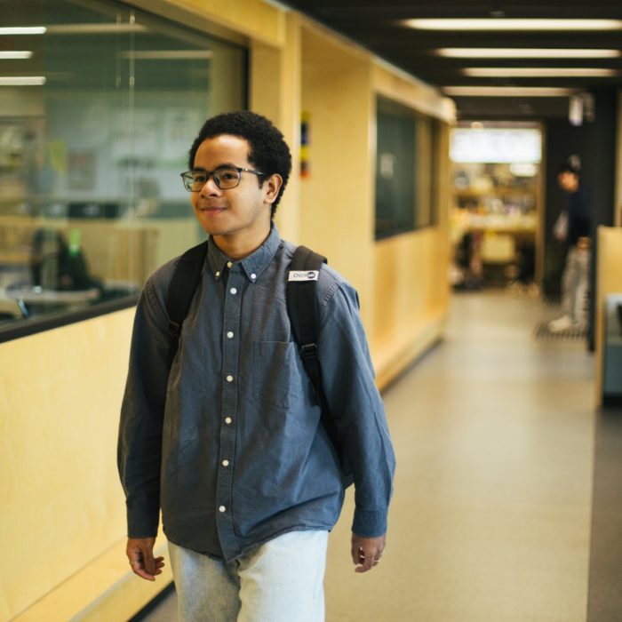 Photo of a student walking through a building on campus