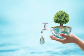 Person holding the Earth with a tree on top and a tap coming out of the Earth