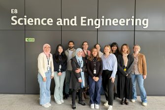 Members of AOM group standing in front of Science and Engineering building