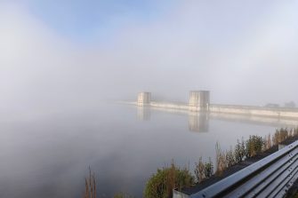 Cordeaux dam wall in mist with road barrier in front
