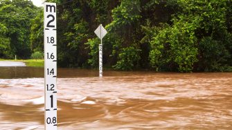 A flooded road with depth indicators in Queensland, Australia