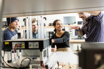 Students work with a lecturer to understand sophisticated practical telecommunications equipment