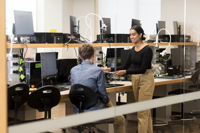 Students work with a lecturer to understand sophisticated practical telecommunications equipment