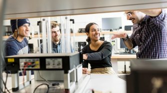 Electrical engineering students in discussion with a teacher