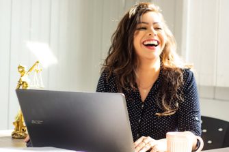 Woman smiling and working on her laptop