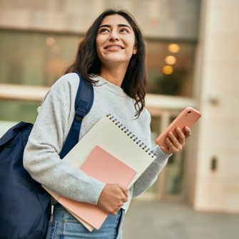 Young middle east student girl smiling happy using smartphone at the city.