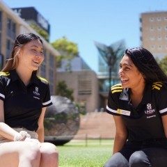 UNSW Engineering students sitting outdoors on campus and talking