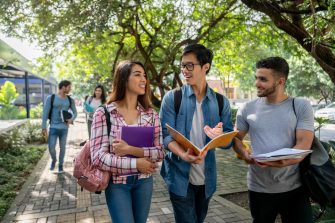 A group of students walking and talking outdoors on campus