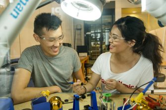 Engineering students working with tools in a workshop