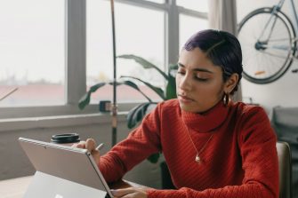 Person in red sweater using a laptop