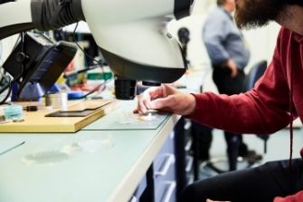 Biomedical engineer looking through a microscope in a lab