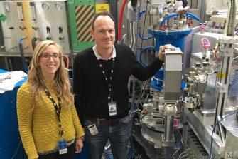 Scientists standing next to nuclear energy research equipment