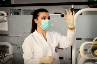 Female Lab Technician looking at object in hand
