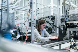 Female robotics engineer on laptop in lab