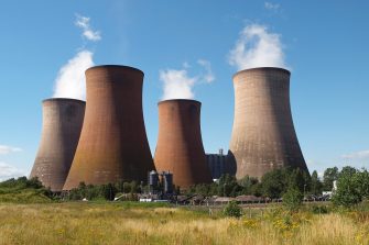 Coal fired power station with cooling towers releasing steam into atmosphere