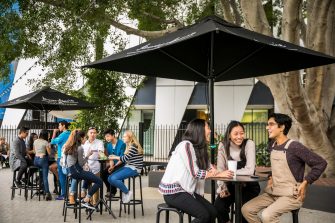 Groups of students are happily chatting at outside tables in the Roundhouse beer garden