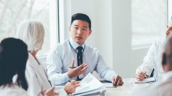 Young hospital administrator meeting with healthcare professionals.