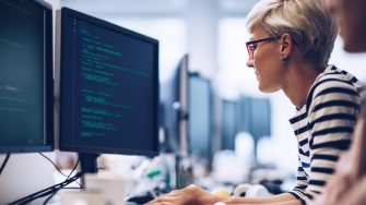 Short haired computer programmer working on a new software in the office.