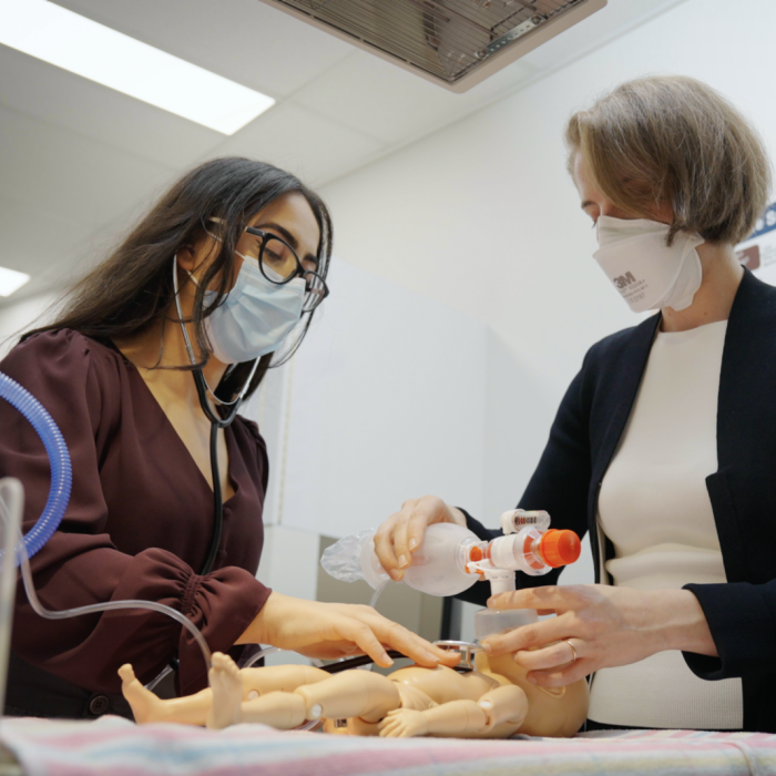 UNSW medicine student working in a simulation room at the hospital alongside a UNSW educator