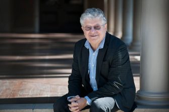 David Brown seated next to a column