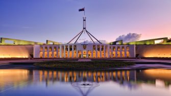 colourful reflection of Canberra's new parliament building in a fontain pond at sunset.