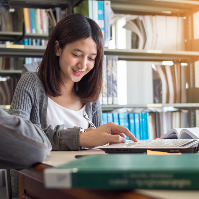 Couple of students studying together at library.