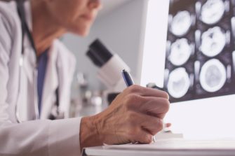 Intelligent female radiologist analyzing with microscope