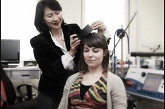 lady with brain scanning equipment being used on patient