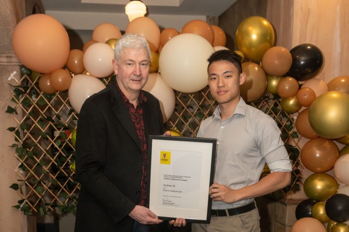 SWS Clinical Medicine Graduate posing for a photo with his award