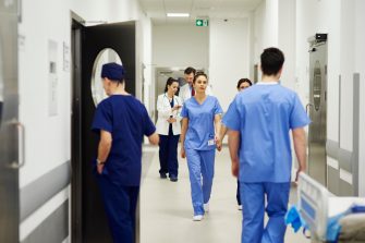 Hospital staff walking through ward