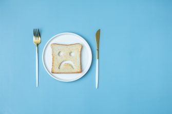 Doctor counselling male patient with abdominal pain in hospital examination room