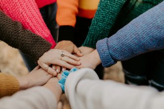 Group of people in a circle putting their hands in together