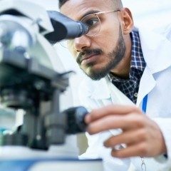 Scientist using microscope in laboratory