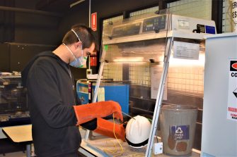 Scientist performing tests on a work hat in lab