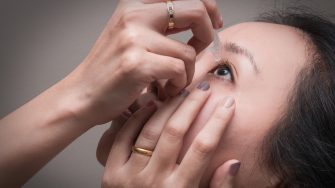 Asian young woman uses eye drops for eye treatment. Redness, Dry Eyes, Allergy and Eye Itching