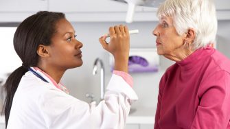 Female Doctor Examining Senior Female Patient's Eyes