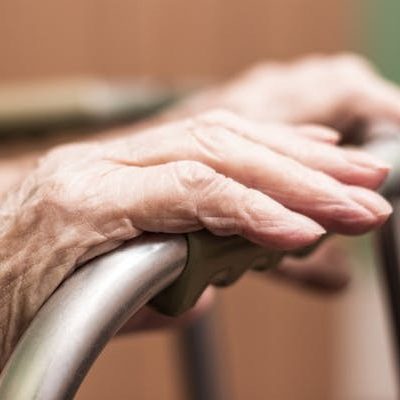 Elderly woman's hands on a walking frame