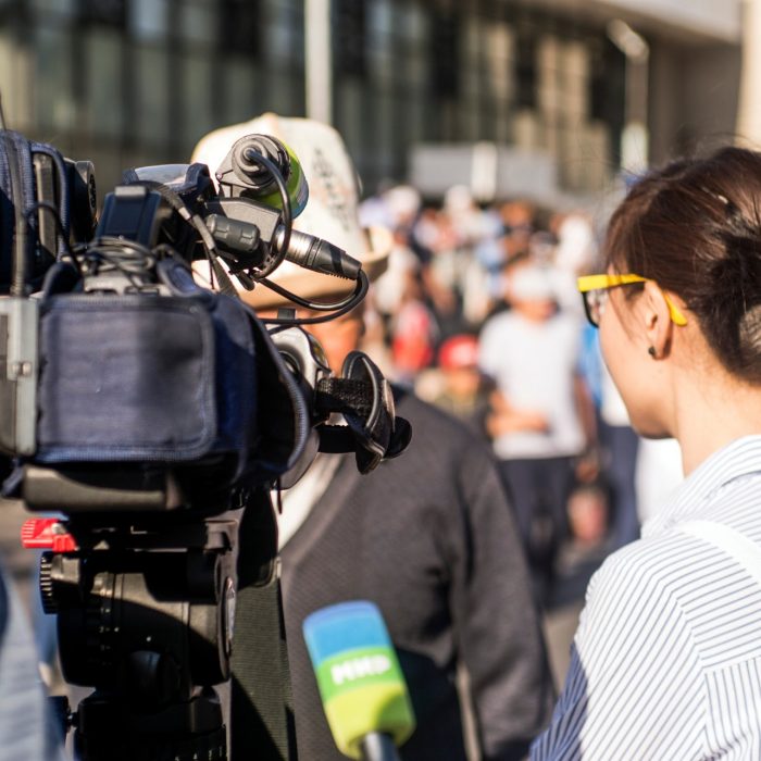 Journalists interview a man on the street.