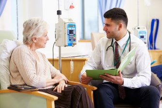 A woman speaking with her doctor in hospital. 
