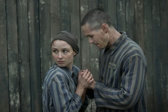 female and male Jewish prisoners at Auschwitz hold hands in fear 