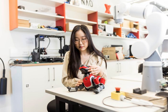 Computer Science Student working with Robotic dog in lab