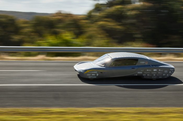 Sunswift solar car on racetrack with sun glinting off of the windscreen