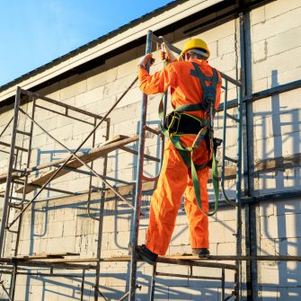 Construction workers wearing safety harness belt during working at high place,Concept of residential building under construction.