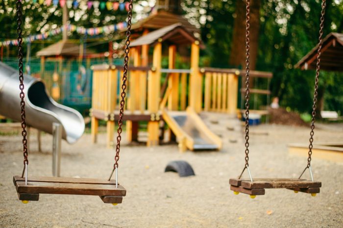 Empty chain swings on playground in the public park close up