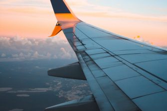 wing of plane in flight with sunset