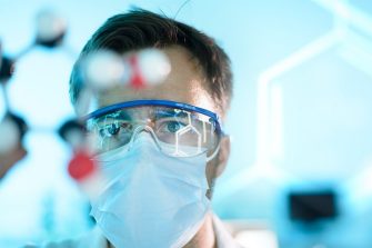 A scientist working with a mask and protective glasses