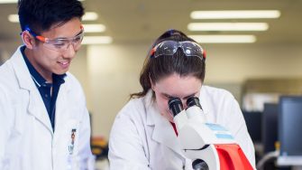 Science students working with a microscope
